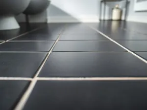 Kielnia i wiadro z zaprawą na bloczkach z betonu komórkowego na tle wznoszonej ściany domu w świetle zachodzącego słońca.